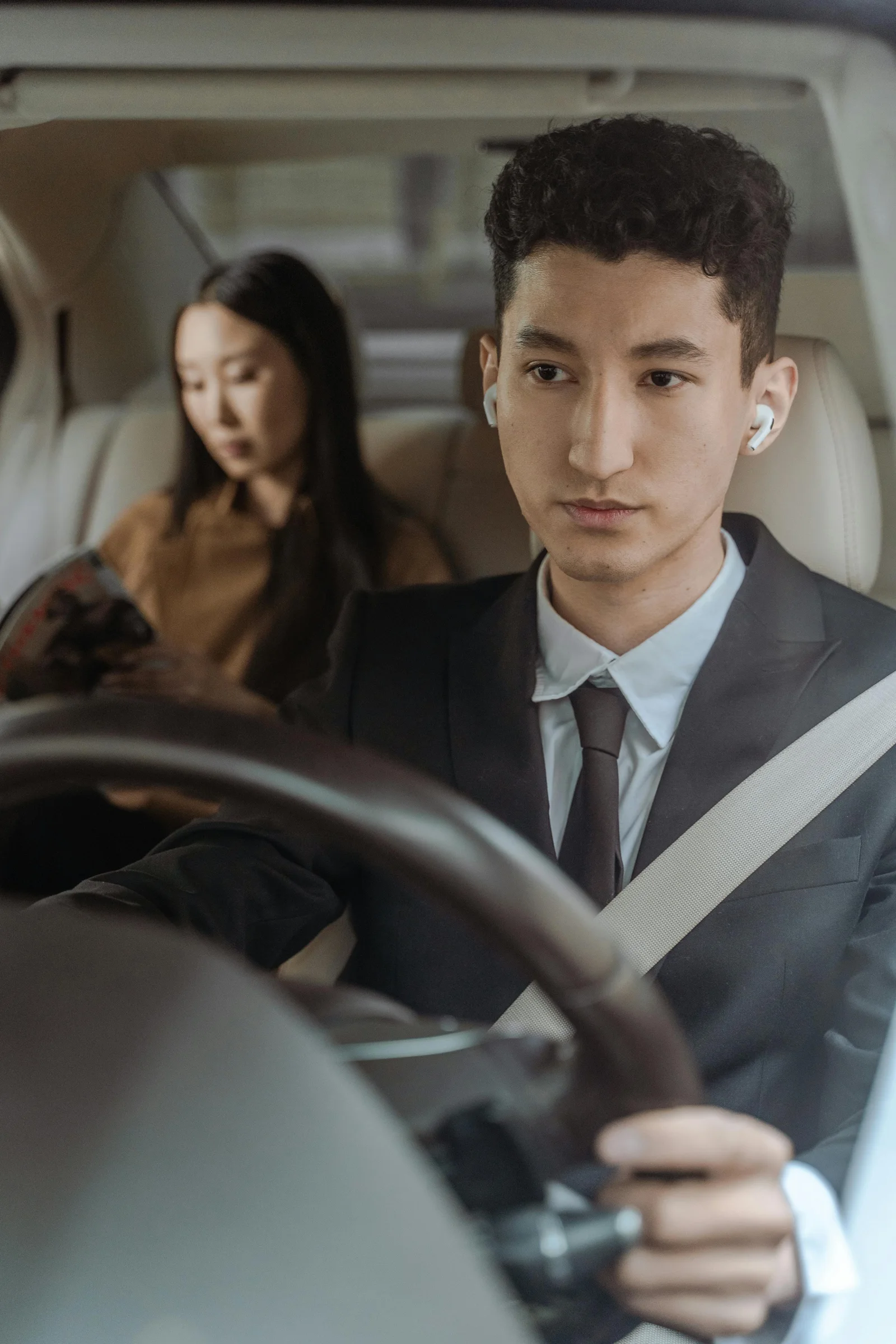 Motorista uniformizado dirigindo carro corporativo
